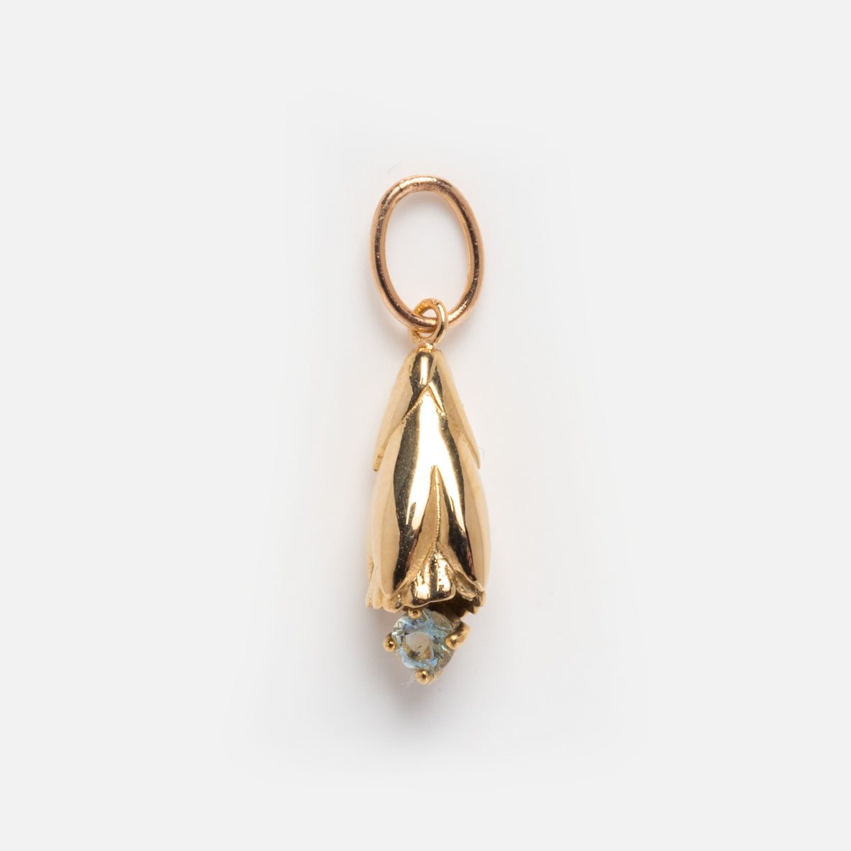 The Solid Gold Birth Flower Bud Charm features a small, gold pendant shaped like a downward-facing flower bud with a round light blue gemstone tip, shown against a white background.