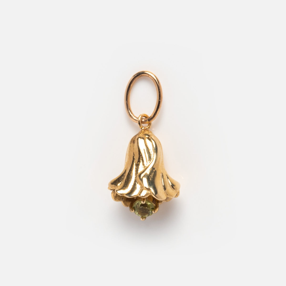 The Solid Gold Birth Flower Bud Charm, shaped like a bellflower with a small green gemstone at the base, hangs from a simple gold loop against a plain white background.
