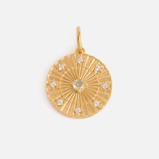 The Charms by Carrie Elizabeth Jewelry pendant features a round, textured 14k gold vermeil design with a central gemstone and eight smaller gemstones around the edge—a striking piece perfect for gemstone jewelry lovers.