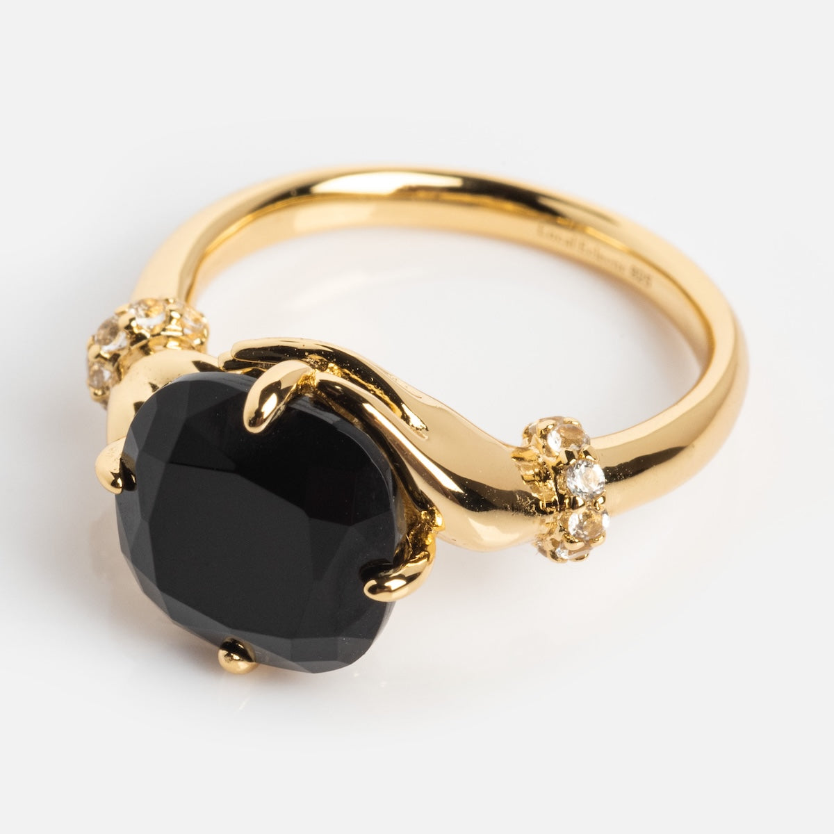 The Past Life Black Spinel Statement Ring is a vintage-inspired gold ring with a bold cushion-cut black spinel center, accented by small clear stones and elegant prongs for unique charm.