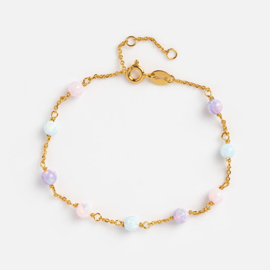 The Pastel Opal Gum Drop Bracelet is a gold vermeil piece adorned with evenly spaced round lab-created opal beads in pastel blue, pink, and purple, finished with a lobster clasp and adjustable extender, shown on a white background.