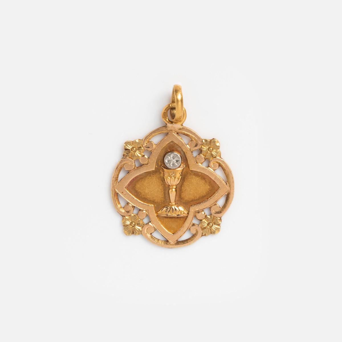Vintage 18k and Platinum French First Communion Charm featuring a chalice with a clear gem, surrounded by decorative floral and lattice designs—ideal for vintage jewelry lovers.
