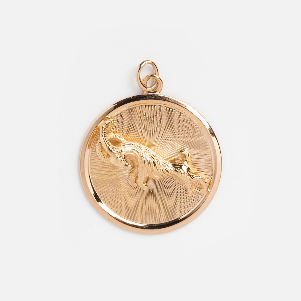 A round gold pendant featuring a raised Aries ram on a textured background—this vintage 18k UnoAerre Italy coin charm is an elegant zodiac-inspired jewelry piece.