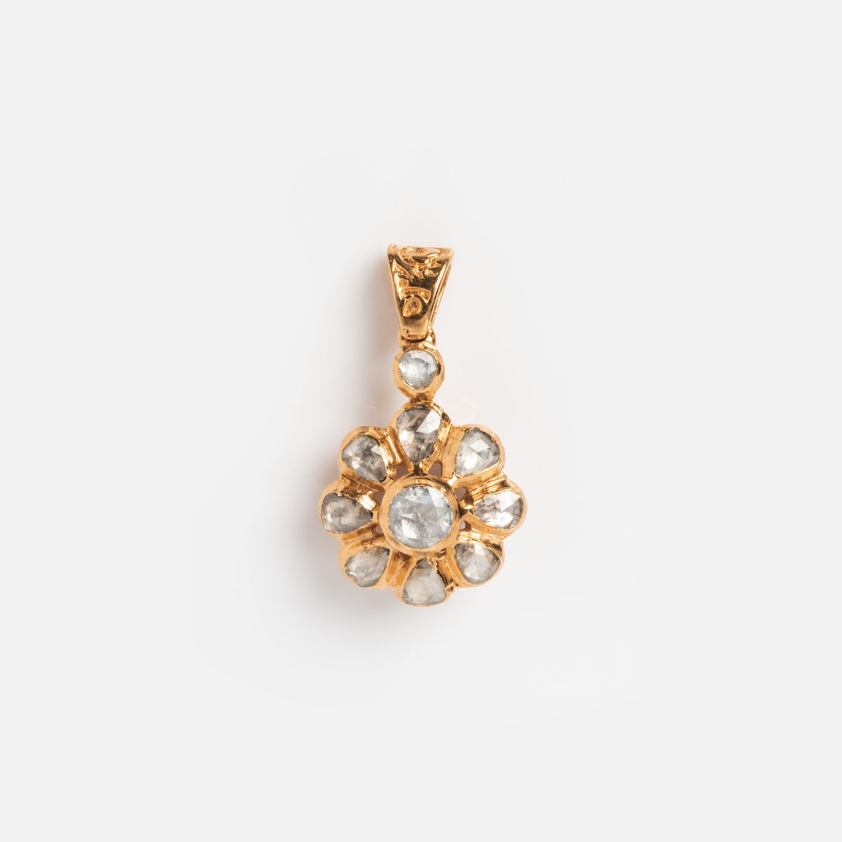 The Vintage 14k Rose Cut Diamond Floral Cluster Charm features a gold floral design with a central round clear stone, surrounded by smaller clear stones in petal-shaped settings, evoking classic vintage diamond charm elegance.