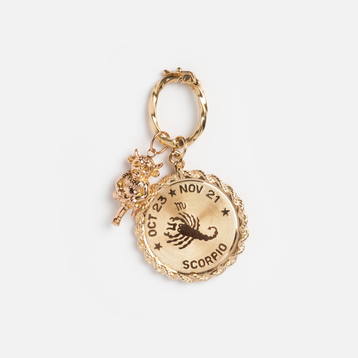 This gold keychain displays a round medallion with a scorpion, Scorpio dates and symbol, and SCORPIO, accented by a small owl charm attached via a Vintage 14k Textured Charm Clip for unique vintage flair.