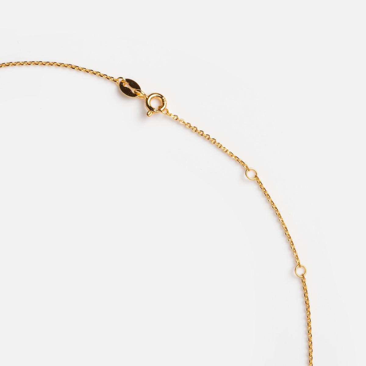 Close-up of the Opal Heart Lariat, a delicate gold vermeil chain necklace with small round links and a lobster clasp, set against a plain white background.