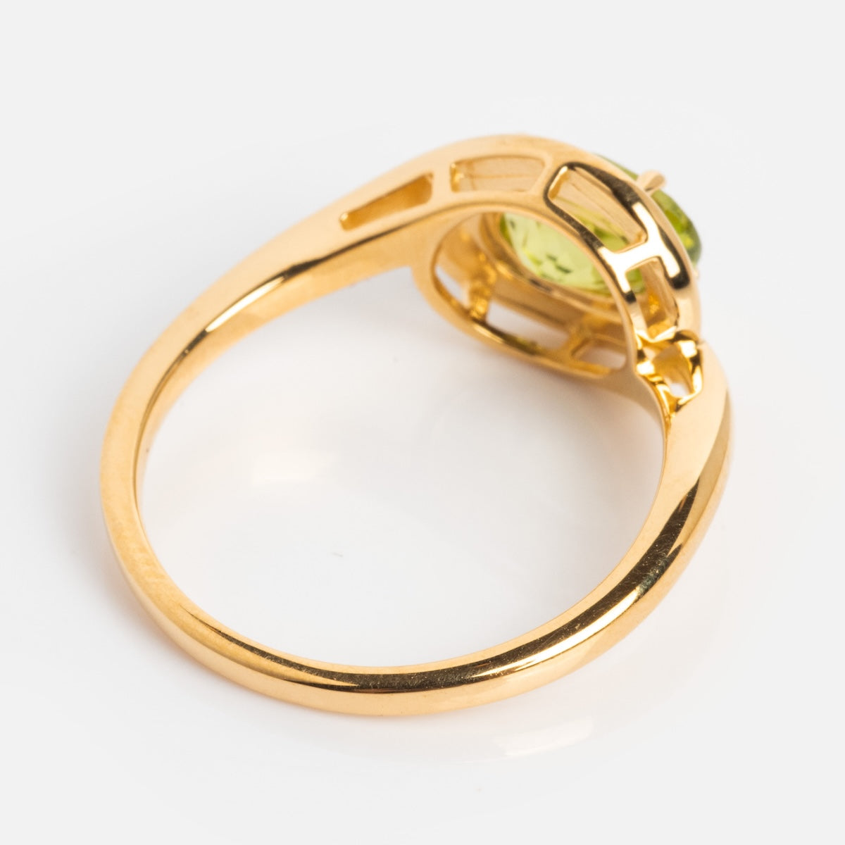 The Peridot Poetry Statement Ring is a vintage-inspired piece in 14k gold vermeil with a green peridot gemstone in a prong setting, displayed from the side on a white background.