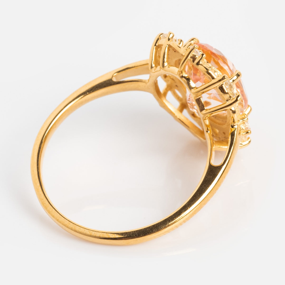 The Royal Blush Cocktail Ring features a large oval peach CZ gemstone in a decorative prong setting, crafted in 14k gold vermeil and shown from the side at an angle on a white background.