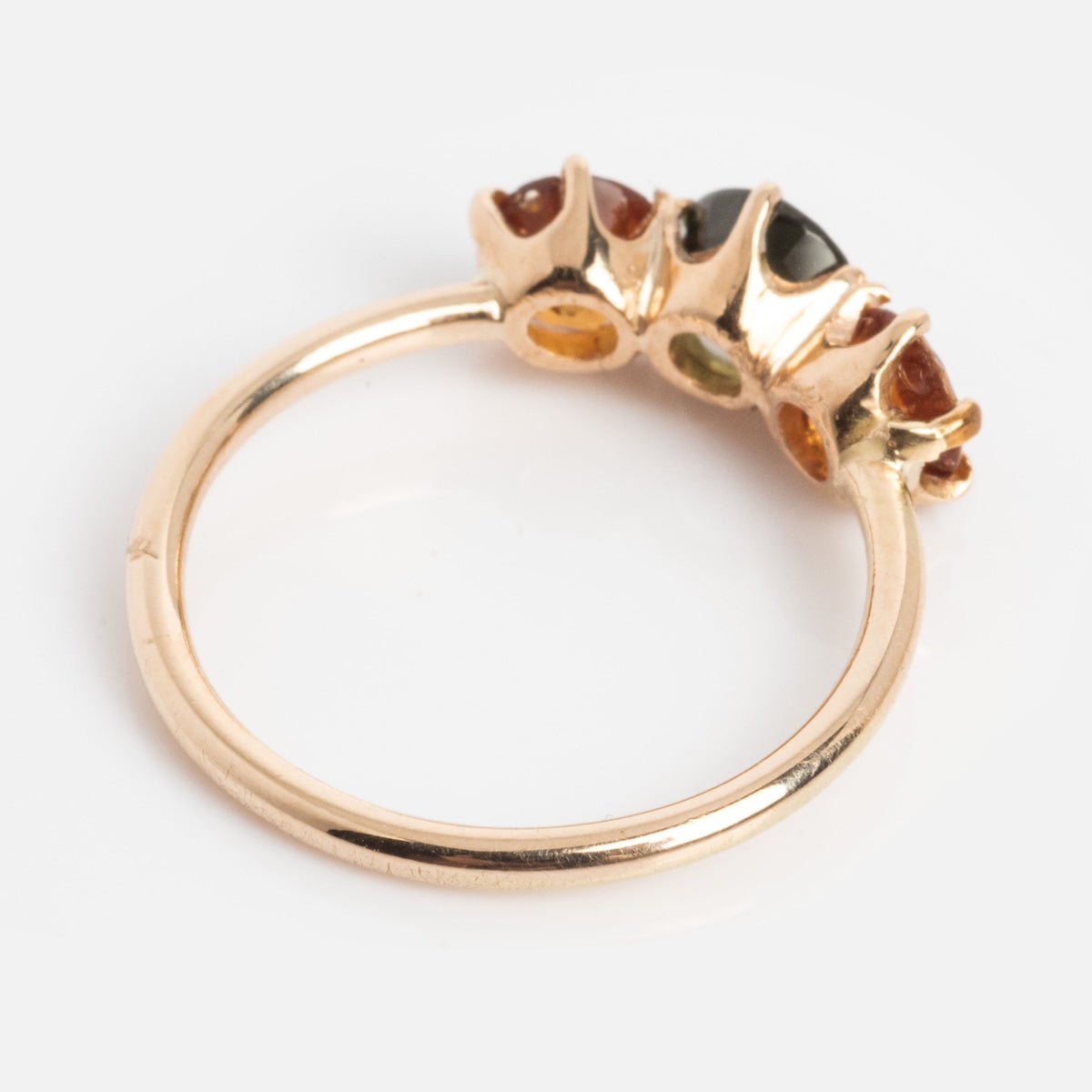 The Vintage 14k 1900s Tourmaline Trio Ring, size 4.5, features three vibrant tourmaline gemstones set in yellow gold and is displayed on a white background.
