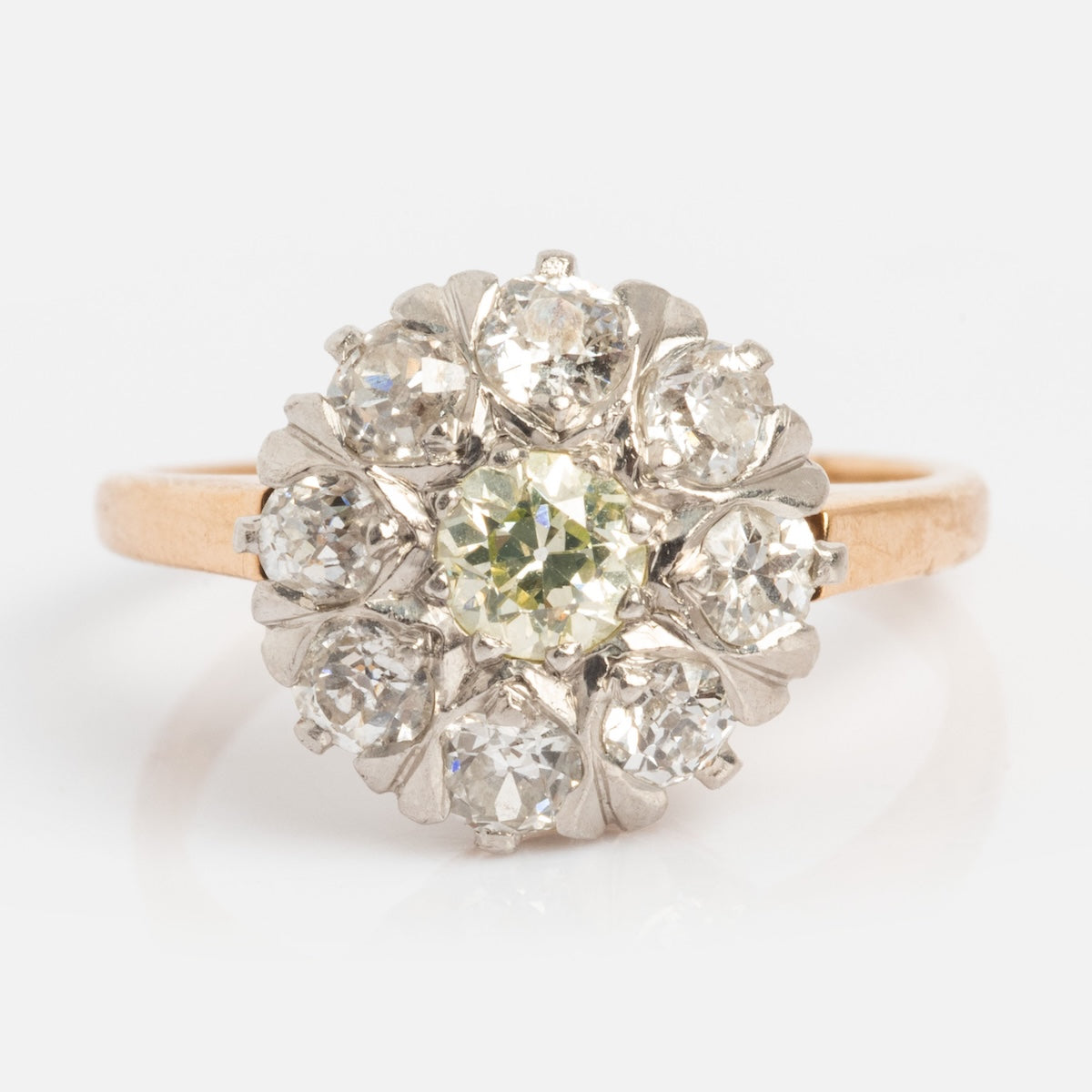 A Vintage 14k 1920s Euro Cut Diamond Cluster Ring, size 5, in yellow gold with a round central euro cut diamond surrounded by eight smaller diamonds in a floral cluster setting.