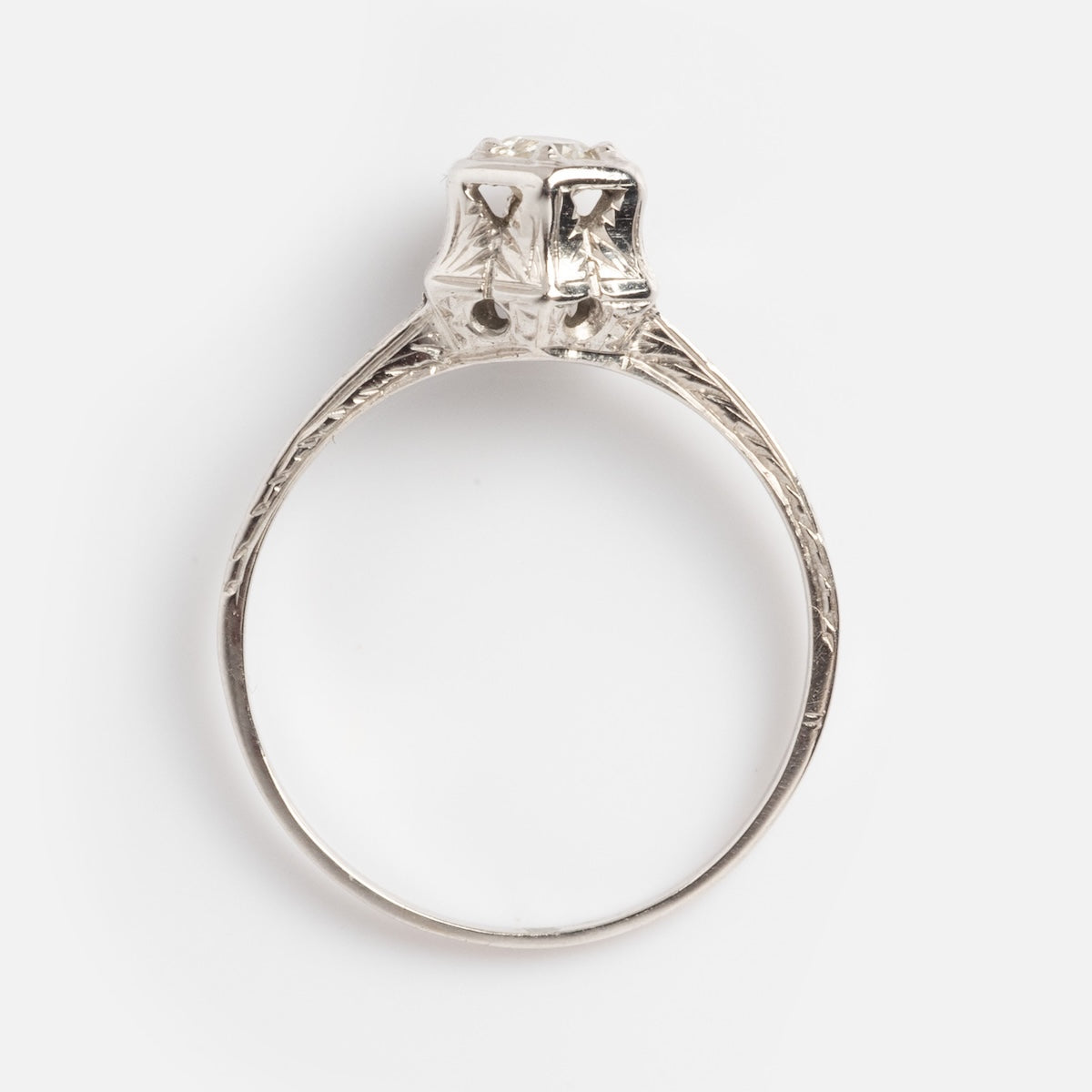 The Vintage 18k White Gold Hexagon Set Diamond Ring, size 7, features intricate vintage-style engraving and a raised hexagonal setting, shown from the side against a plain white background.