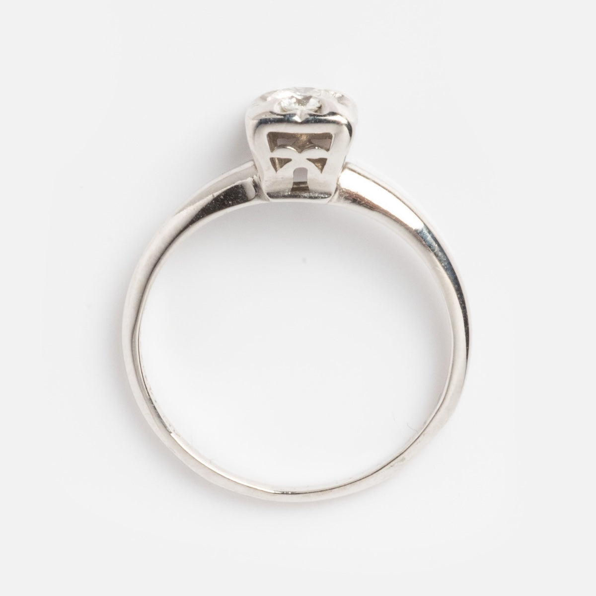 A vintage 14k 1940s white gold square set diamond ring in size 7, shown from the side with a sparkling diamond in a raised prong setting against a plain white background.