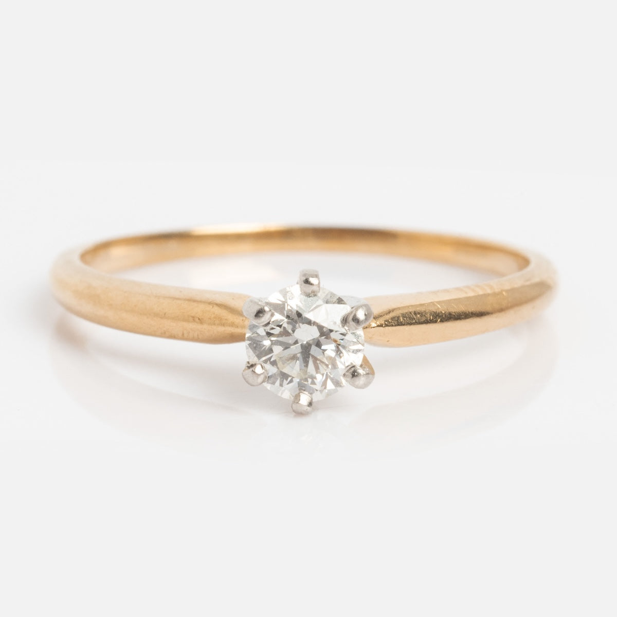 Vintage 14k 1960s Solitaire Round Diamond Engagement Ring, size 5.5, features a single round diamond in a classic six-prong setting on a white background.