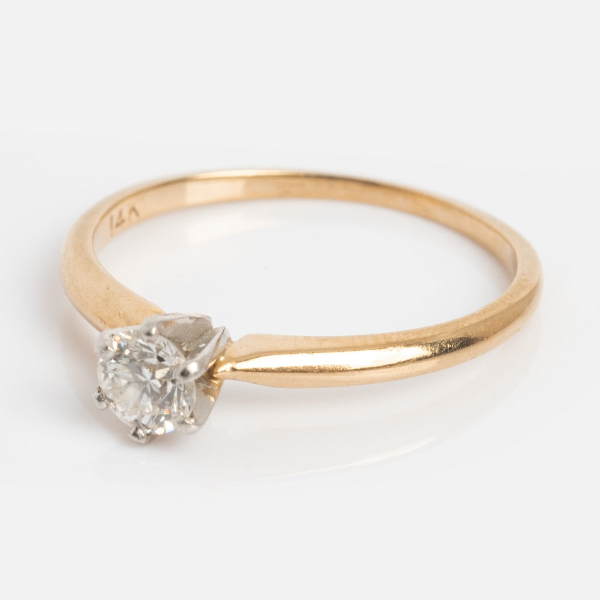A vintage 14k gold engagement ring from the 1960s with a solitaire round diamond, size 5.5, is displayed on a white background.