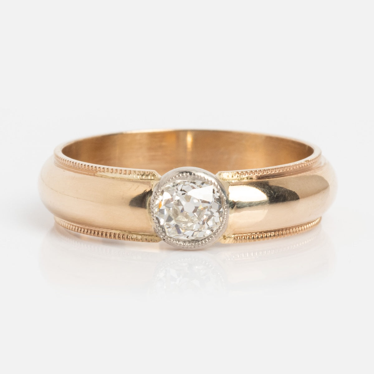 The Vintage 14k 1900s Euro Cut Diamond Classic Band in size 7.5 features a round, bezel-set diamond centerpiece and fine milgrain detailing along the edges.
