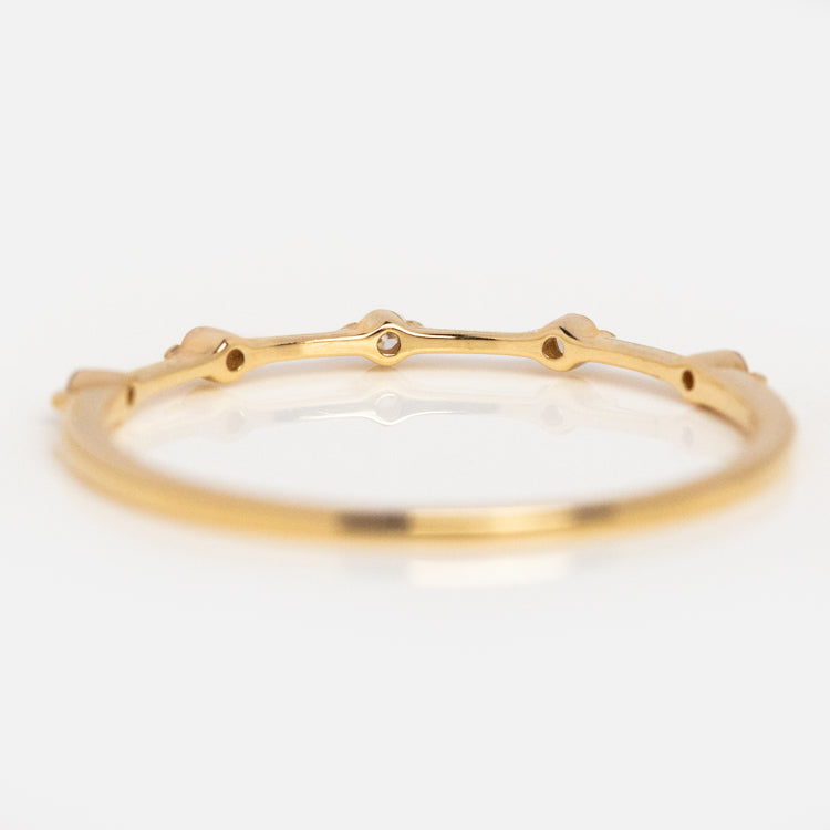 The 14k Diamond Constellation Band features a smooth, thin 14k gold band adorned with small, evenly spaced diamond accents around its circumference, shown on a white background.