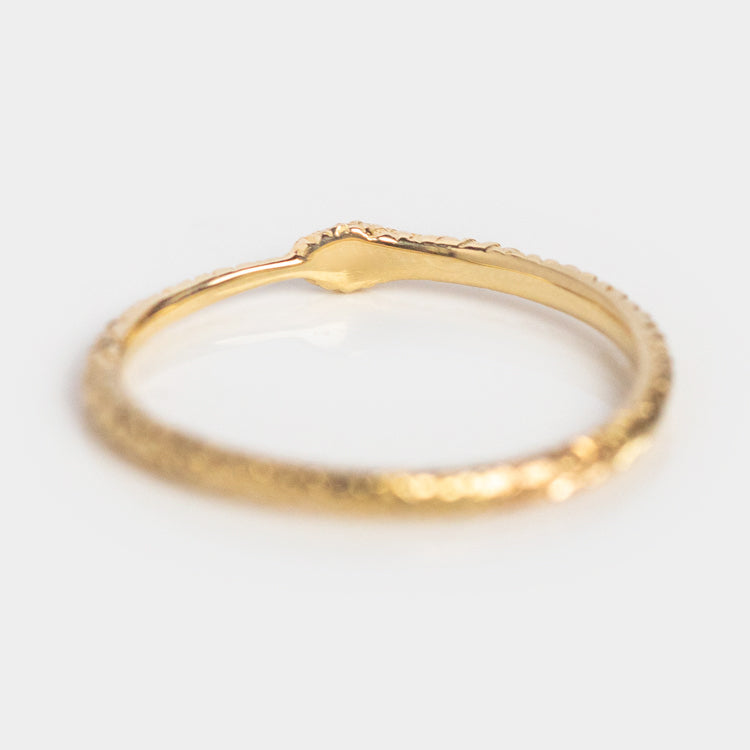 The Ouroboros Diamond Snake Ring features a textured gold band with a small raised detail, displayed on a plain white background.