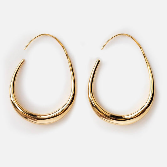 Fluid Hoop Earrings in yellow gold plating with a smooth, polished finish and subtle crescent teardrop shape, shown against a plain white background.