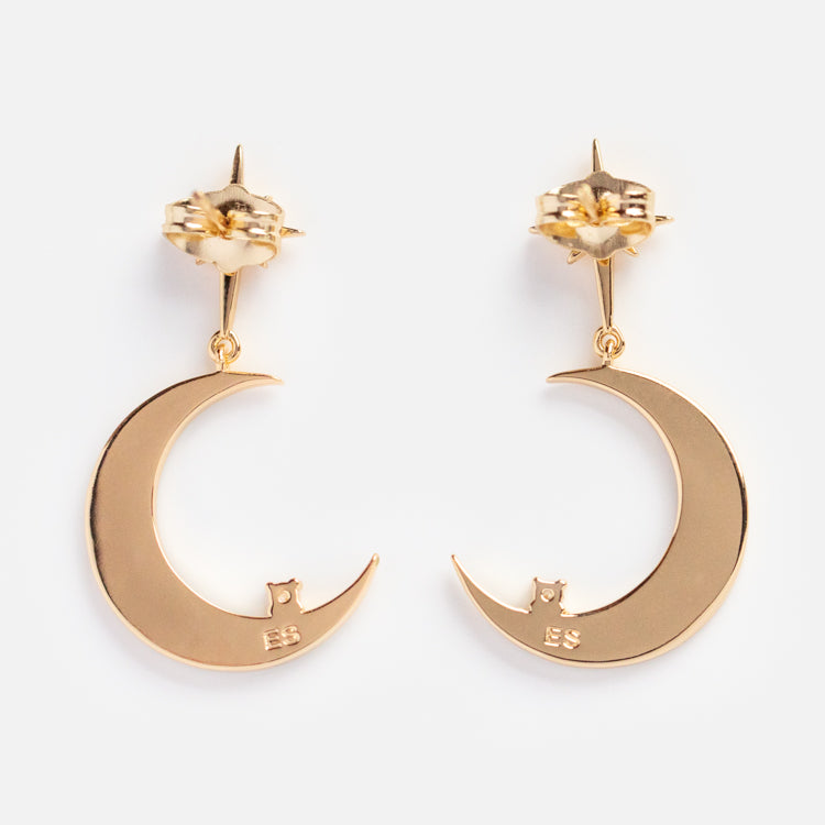 The La Lune Teal Green Earrings feature gold crescent moons with a small cat sitting inside each one, and the letters ES engraved near the bottom.
