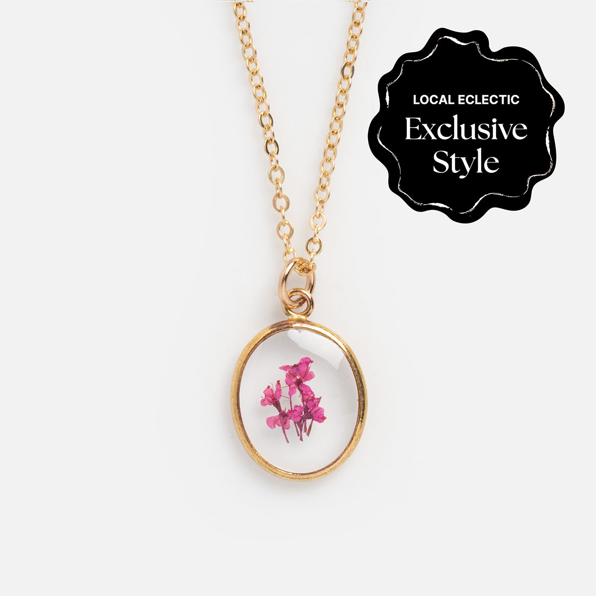 Tiny Birth Flower Portrait Necklace with a round pendant featuring small pink blooms, reminiscent of Queen Annes lace. A black label in the top right corner reads LOCAL ECLECTIC Exclusive Style.