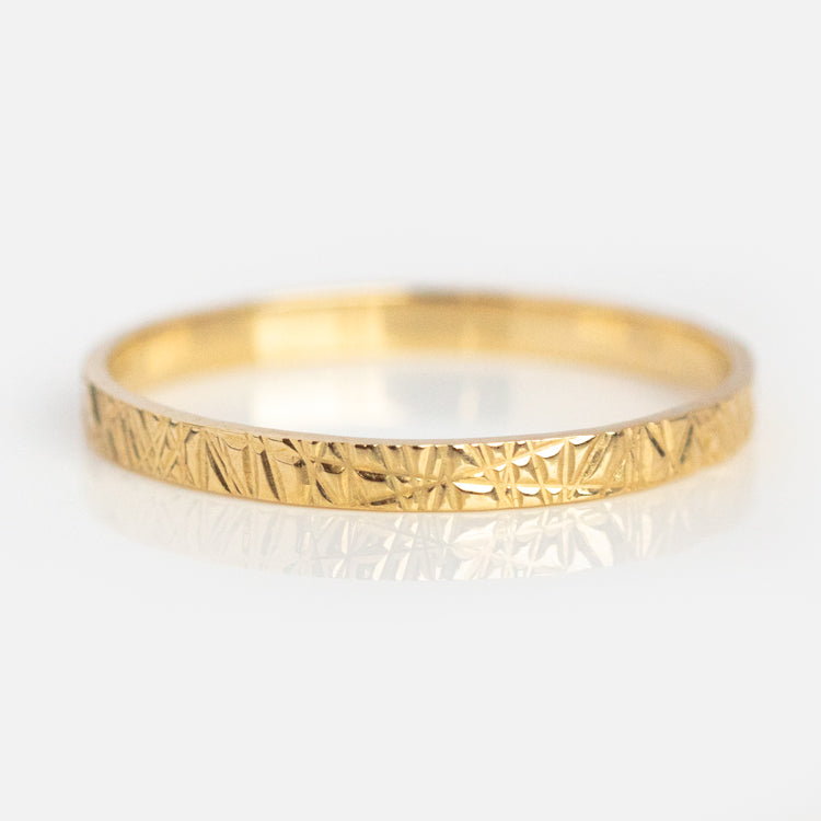 The Solid Gold Etched Band Ring features a thin recycled gold band with an engraved, textured pattern, shown on a white background.