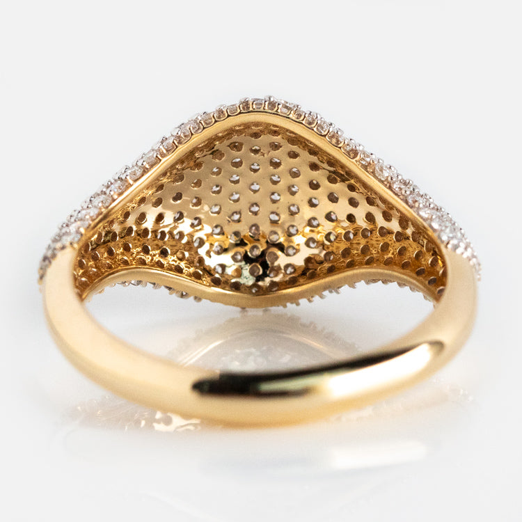 A close-up of the underside of the 14k Solid Gold Pave Diamond Signet Ring highlights its textured, perforated pattern and a row of sparkling pave diamonds, beautifully displayed against a white background.