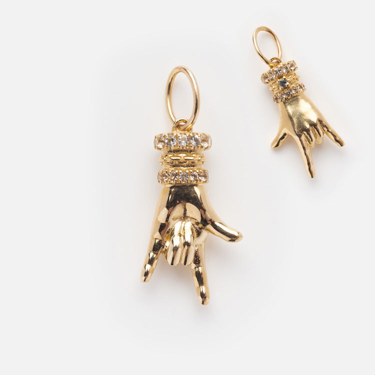 The Solid Gold Body Language Charm features two hand-shaped charms making the American Sign Language I love you gesture, adorned with sparkling rhinestone bands. A Local Eclectic exclusive, shown on a white background.