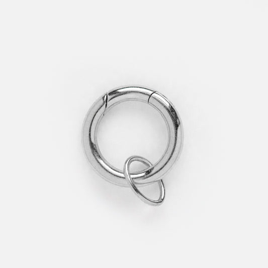 Featuring the Solid Gold Charm Clip in White Gold, this shiny silver hoop earring has a charm clip and a smaller ring attached, elegantly displayed against a plain white background.