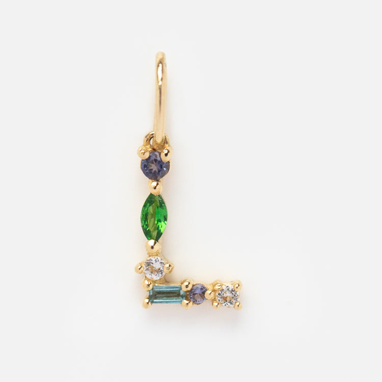 The Solid Gold Gemstone Letter Charm features a personalized L design, beautifully accented with green, blue, purple, and clear gems in an elegant setting.