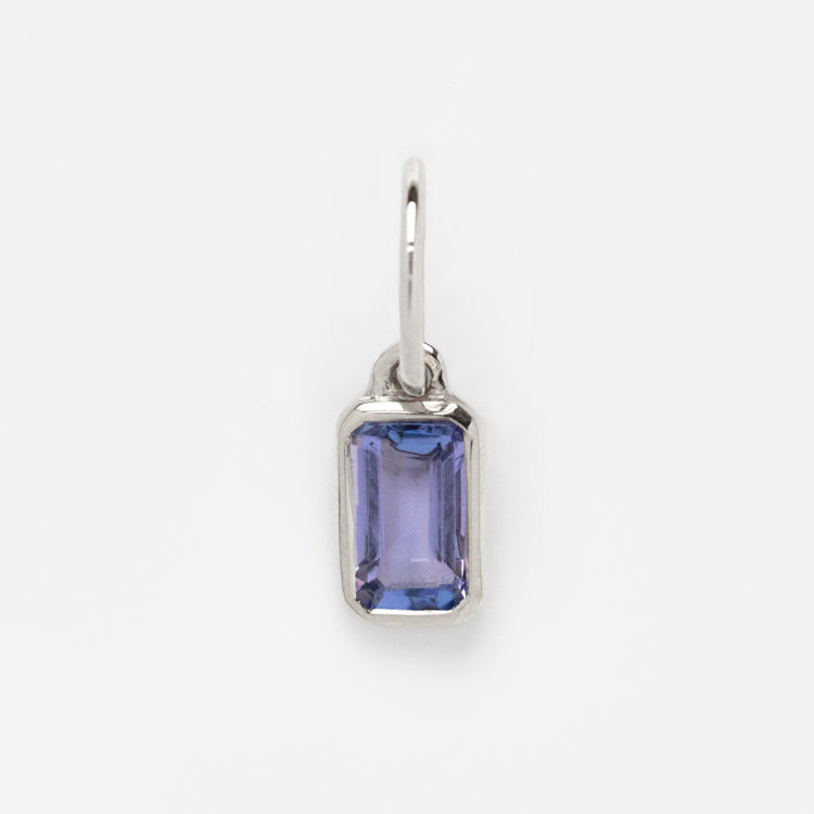 The Solid Gold Birthstone Baguette Charm in White Gold features a faceted, light purple gemstone in a sleek rectangular pendant—ideal for lovers of personalized jewelry, shown on a plain white background.