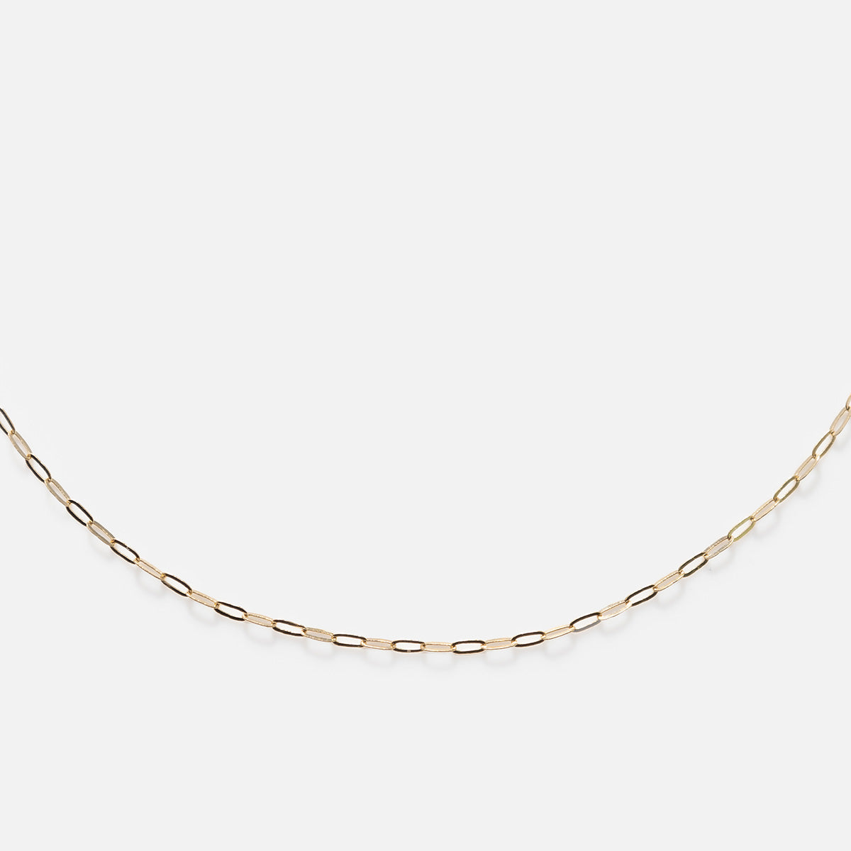 The Solid Gold Chain for Charms features small, evenly spaced oval links in a delicate design, shown against a plain white background—an ideal choice for a timeless charm necklace.