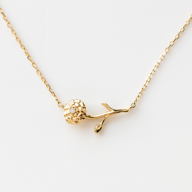 The Solid Gold Birth Flower Necklace October Sample features a delicate 9k yellow gold pendant shaped like a flower with textured petals and stem, inspired by natural opal, on a fine gold chain.
