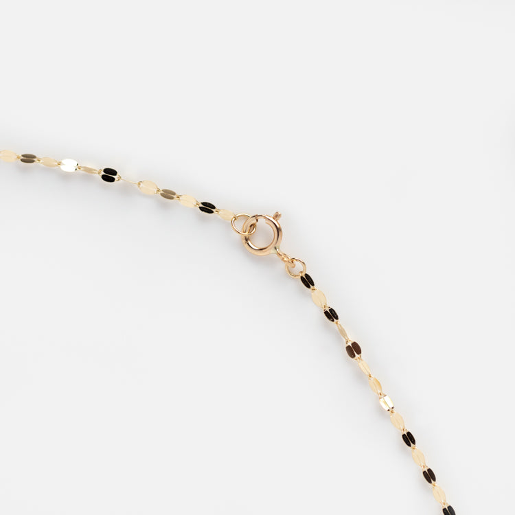 A close-up of the Solid Gold Sparkle Link Chain, a delicate 14k gold necklace with small oval links and a spring ring clasp, showcased against a plain white background.