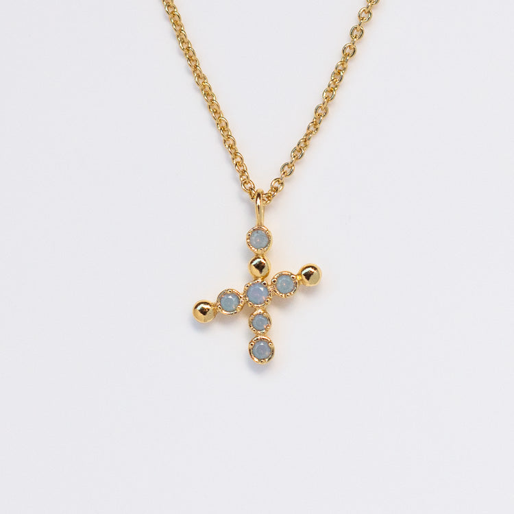 The Initial Charm Necklace Sample features a 14k yellow gold plated chain with a cross-shaped opalescent nano gems pendant, each tip embellished with shimmering stones, shown on a plain white background.