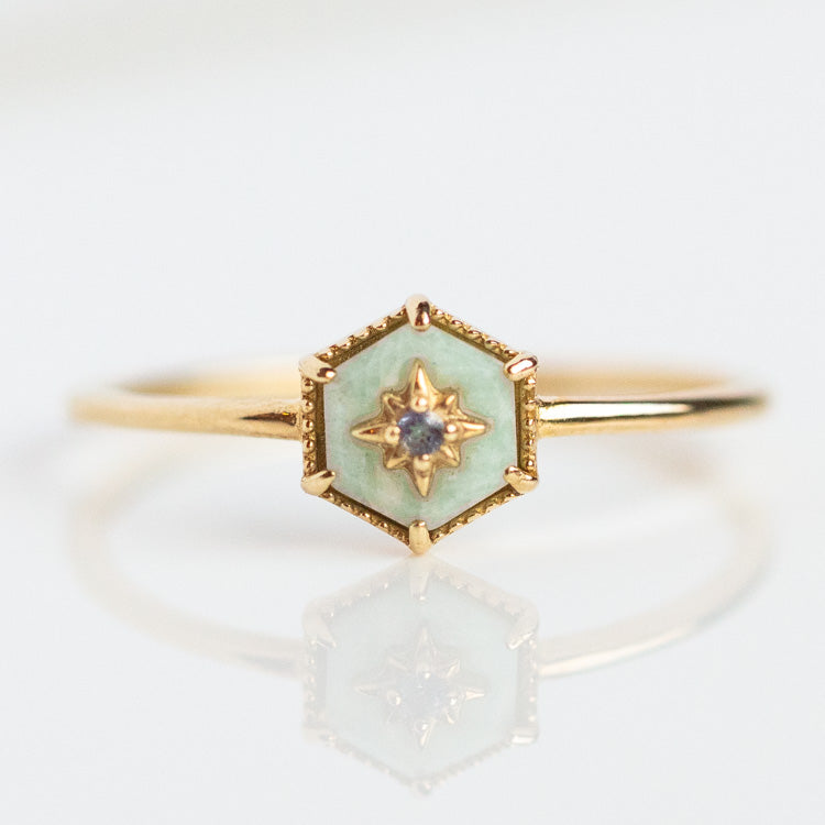 The Solid Gold Crystal Ring for Manifestation in Amazonite (Size 7) features 9k yellow gold with a hexagonal mint green enamel setting and a central diamond in a star-shaped gold design, shown on a white surface with a subtle reflection.