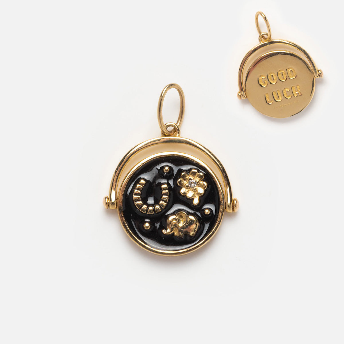 The Solid Gold Coin Charm is a Local Eclectic exclusive pendant with a black background featuring a horseshoe, four-leaf clover, and elephant; the reverse side is engraved with GOOD LUCK. A unique piece of personalized jewelry.