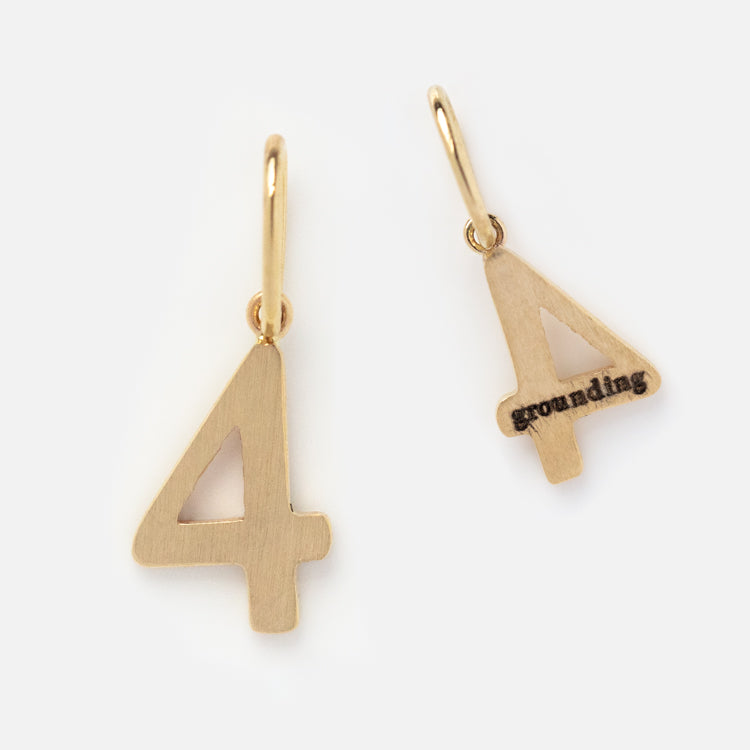The Solid Gold Number Charm comes in the shape of 4, in both large and small sizes. The smaller charm is engraved with grounding. Each charm features a loop at the top for easy attachment to personalized jewelry.