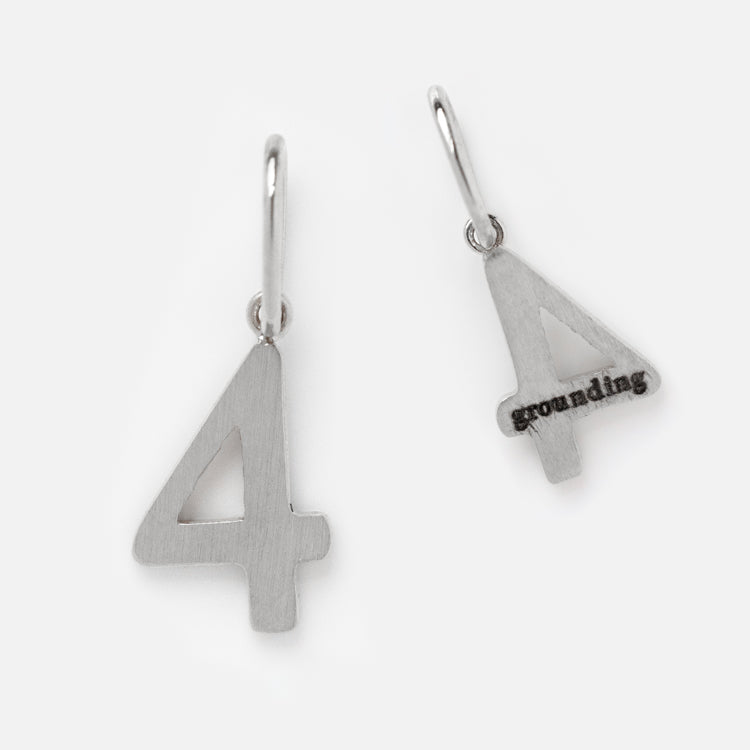 Two Solid Gold Number Charms in White Gold shaped like the number 4—one plain, one engraved with grounding. Each features a small loop for adding to personalized jewelry. Photographed against a crisp white background.
