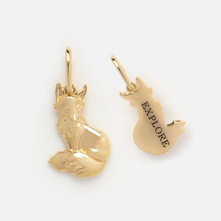 The Solid Gold Nature Charm features two animal designs—one with a sitting fox and one with its back engraved EXPLORE. Both solid gold charms include loops for easy attachment to your favorite jewelry.