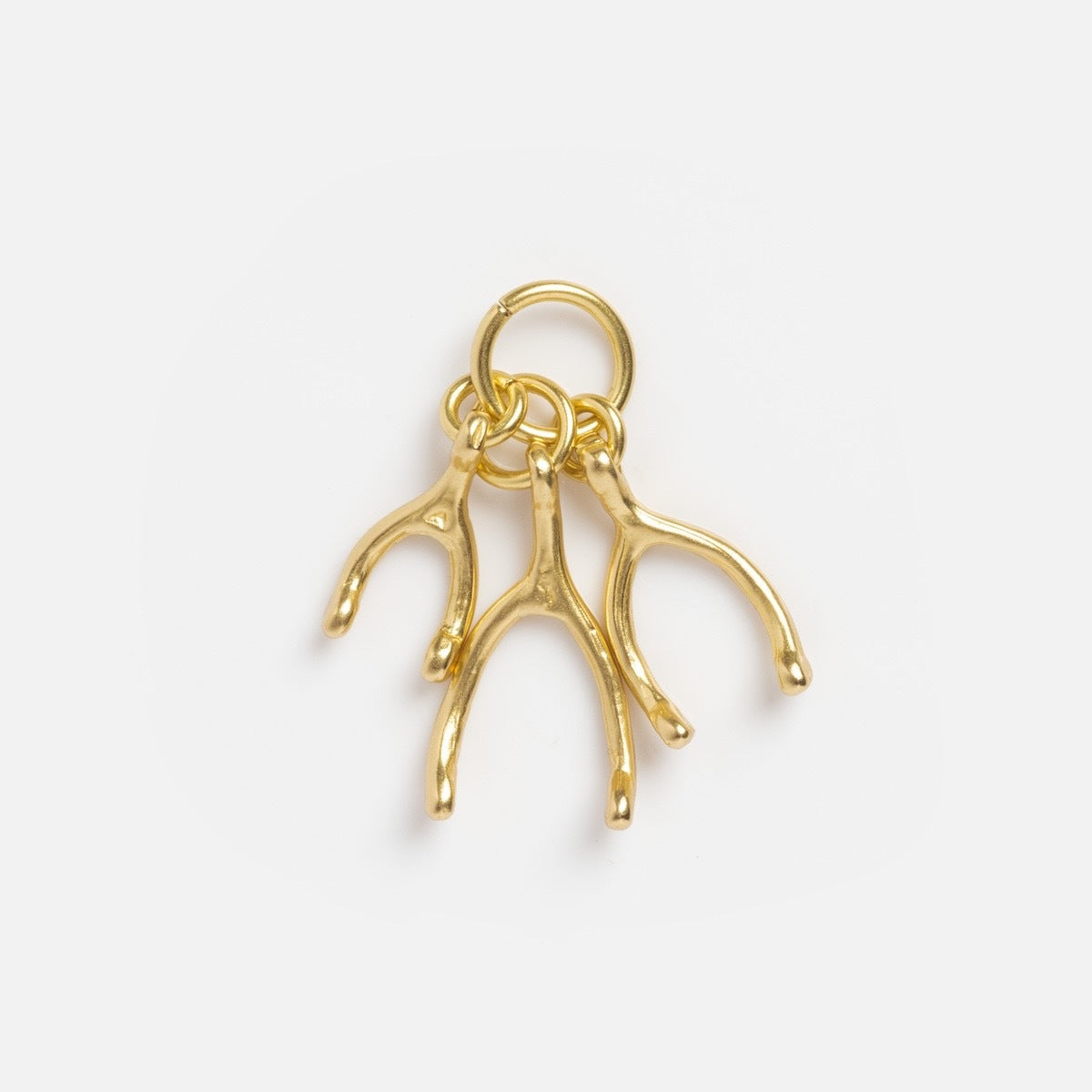 Three small gold Charms by Satomi Studio brass wishbone charms hang from a gold key ring against a plain white background.