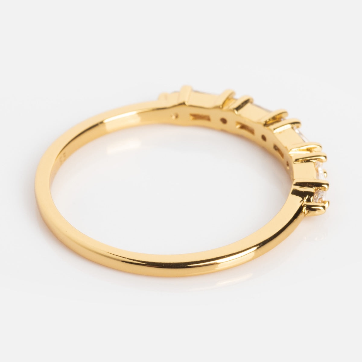 The Multi Gem Baguette CZ Stacking Ring is a 14K gold plated, thin band ring featuring a row of clear baguette-cut cubic zirconia set in prongs along the top, displayed on a white background.