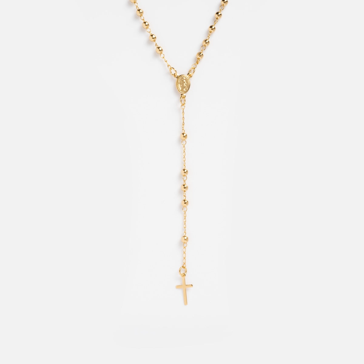 The Gold Rosary Necklace features 14k gold plating, small beads, an oval medallion, and a cross pendant on a plain white background—an elegant piece of faith jewelry for everyday wear.