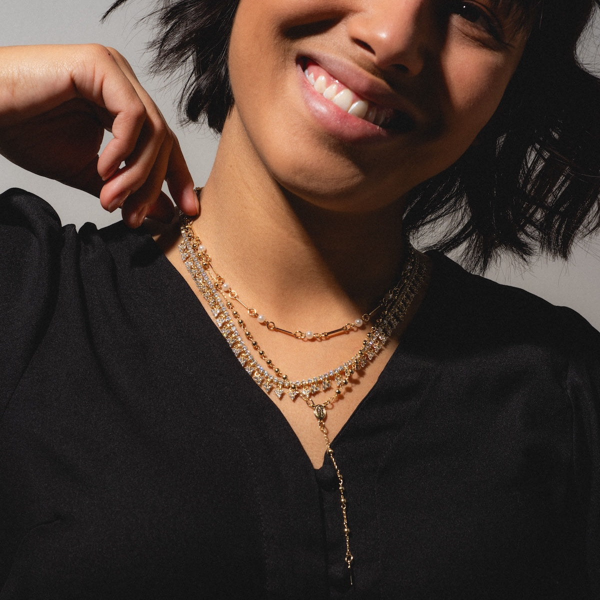 A woman wearing a Gold Rosary Necklace—an elegant 14k gold plated faith jewelry piece.