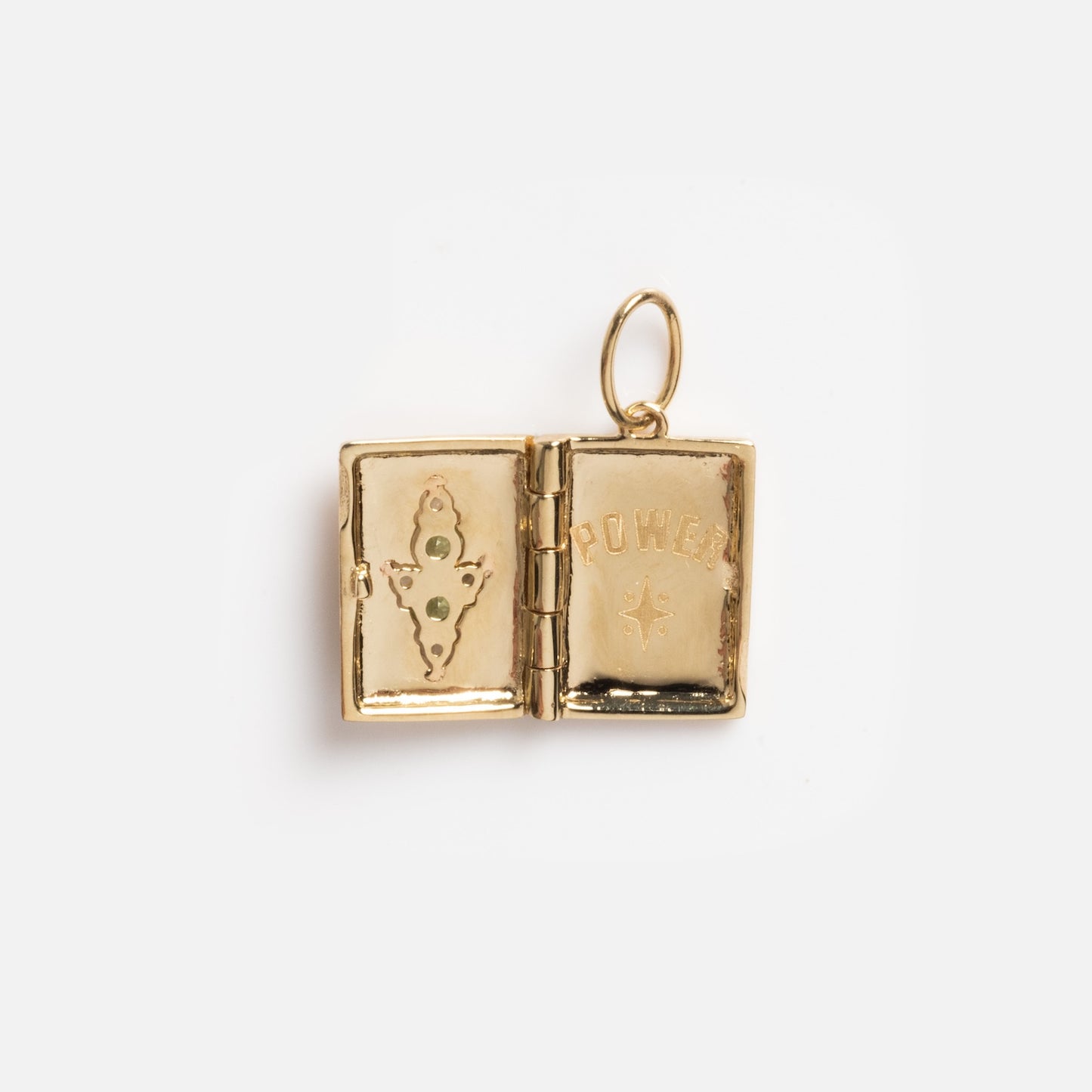 The Solid Gold Amulet Charm is a small book-shaped locket that opens to reveal "POWER" and a starburst. Ornamental details frame a green gem on the back for evil eye protection, with a loop for wearing as jewelry.