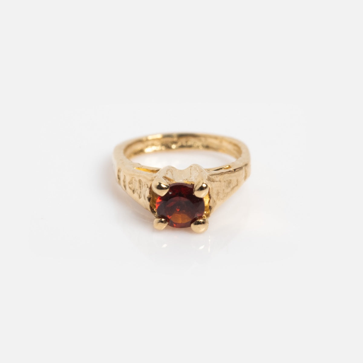 The 14k Littlest Birthstone Ring Charm features a round, deep red gemstone in a prong setting, reflecting Charlie and Marcelle’s signature style—an elegant gold ring charm displayed on a white background.