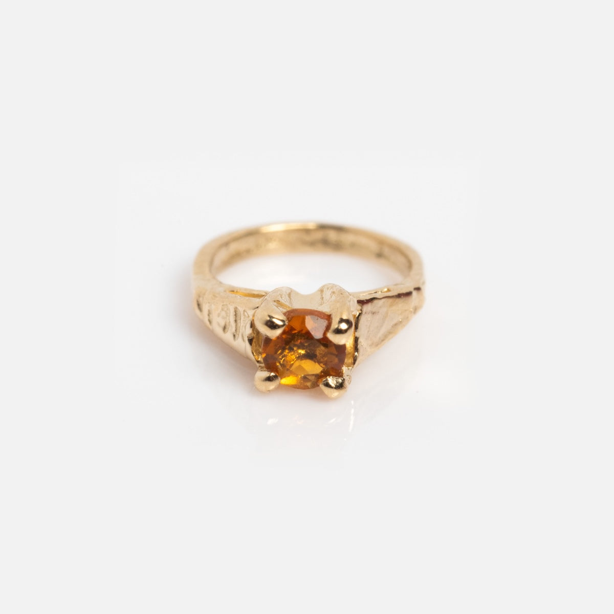 The 14k Littlest Birthstone Ring Charm features a single round amber-colored gemstone in a four-prong gold setting, inspired by Charlie and Marcelles classic design, shown against a white background.