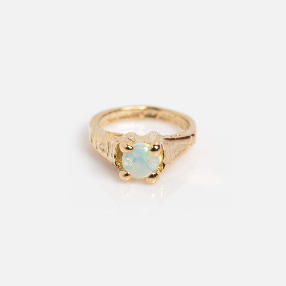 The 14k Littlest Birthstone Ring Charm by Charlie and Marcelle features a gold band with a central iridescent opal gemstone, beautifully showcased on a plain white background.