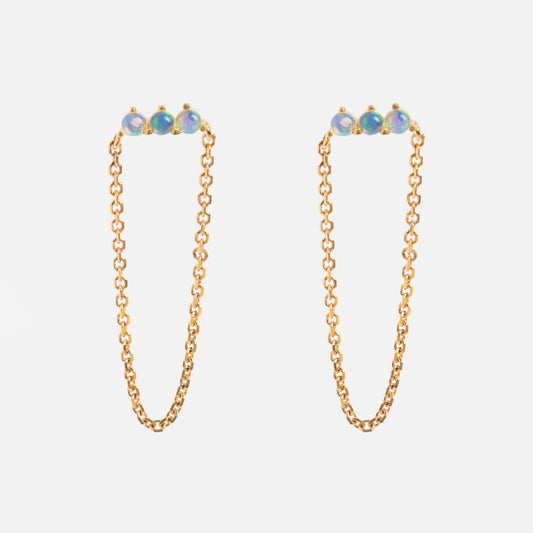 The Solid Gold Opal Trio Chain Dangle Studs feature three small Ethiopian opals at the top of each earring, shown on a plain white background.