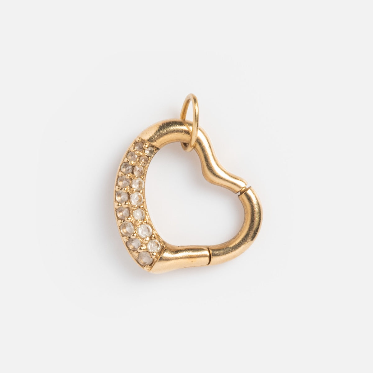 The Solid Gold Charm Clip is a heart-shaped charm with a small top loop, partly adorned with sparkling white stones on one side—ideal for adding to a bracelet or personalized necklace. Shown on a plain white background.