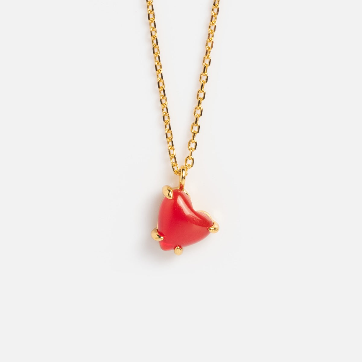 The Limited Edition Full Heart Necklace Sample is a 14k gold plated chain with a red agate heart pendant, accented by small gold prongs at each corner and shown on a plain white background.
